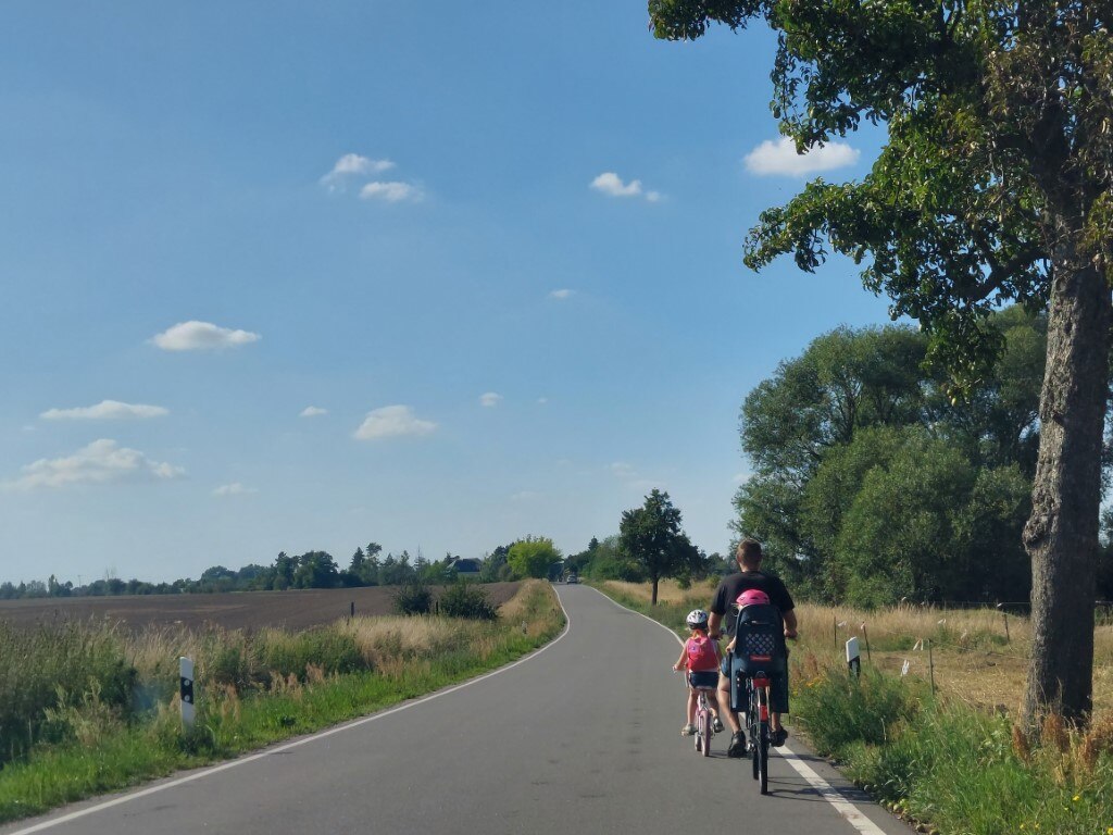 Familie mit Fahrrädern auf einem Radweg im ländlichen Raum