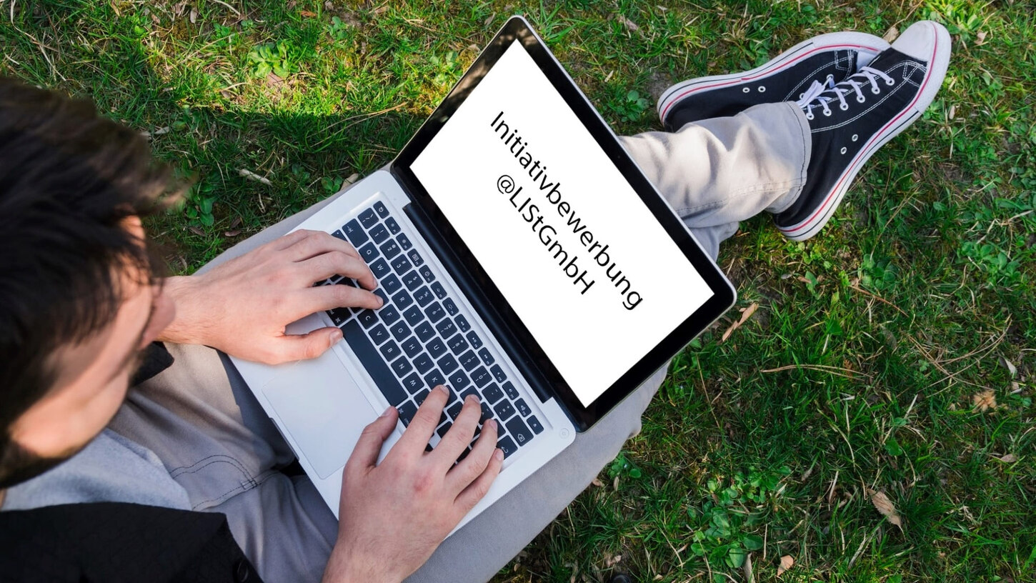 Mann sitzt mit Laptop auf der Wiese mit der Aufschrift auf dem Bildschirm Initiativbewerbung @LISt GmbH