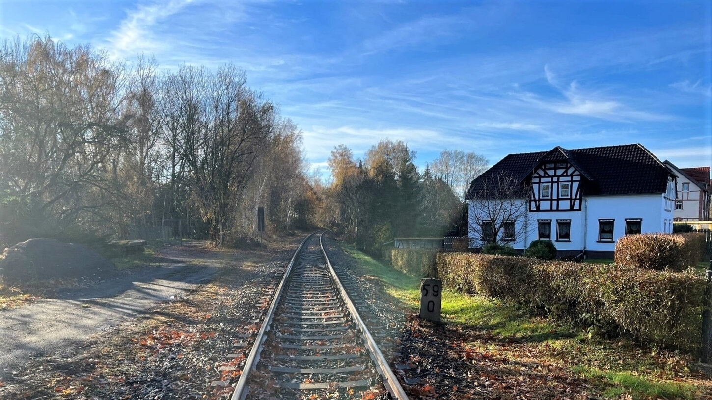 Bahnstrecken in Altlöbau auf dem Streckabschnitt Löbau-Ebersbach im Herbst bei Sonnenschein neben einem Einfamilienhaus
